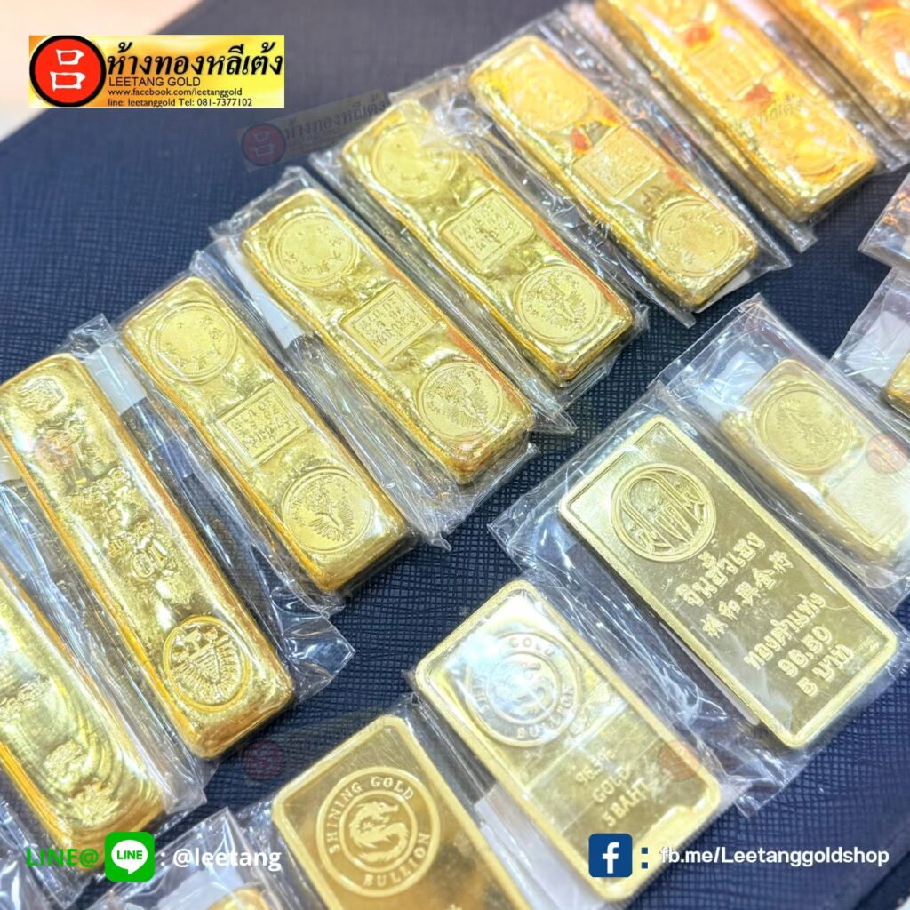 แถวของแท่งทองและเหรียญทอง บางชิ้นห่อด้วยพลาสติกใส จัดวางบนพื้นผิวสีเข้ม พร้อมโลโก้ร้านที่มุม — เหมาะอย่างยิ่งเป็นของรับไหว้งานแต่ง หรือเป็นส่วนหนึ่งของชุดทองแต่งงานของคุณ.