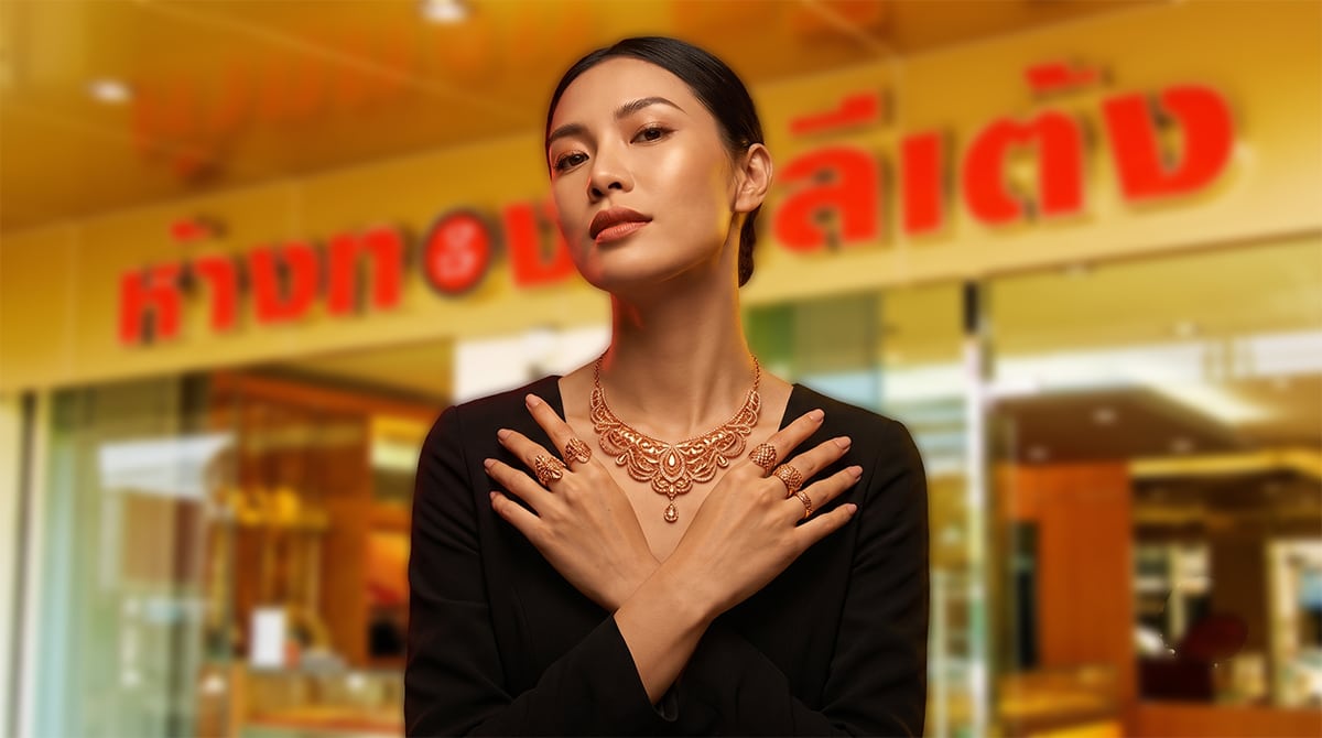 ผู้หญิงคนหนึ่งสวมชุดสีดำ โพสท่าด้วยมือไขว้กัน โชว์เครื่องประดับทองที่ประดับประดาอย่างวิจิตร รวมถึง เข็มขัดนาค และ สร้อยนาค ที่สวยงามตระการตา ยืนอย่างภูมิใจหน้าร้านเครื่องประดับที่มีป้ายภาษาไทยเขียนว่า บริการรับซื้อนาค.